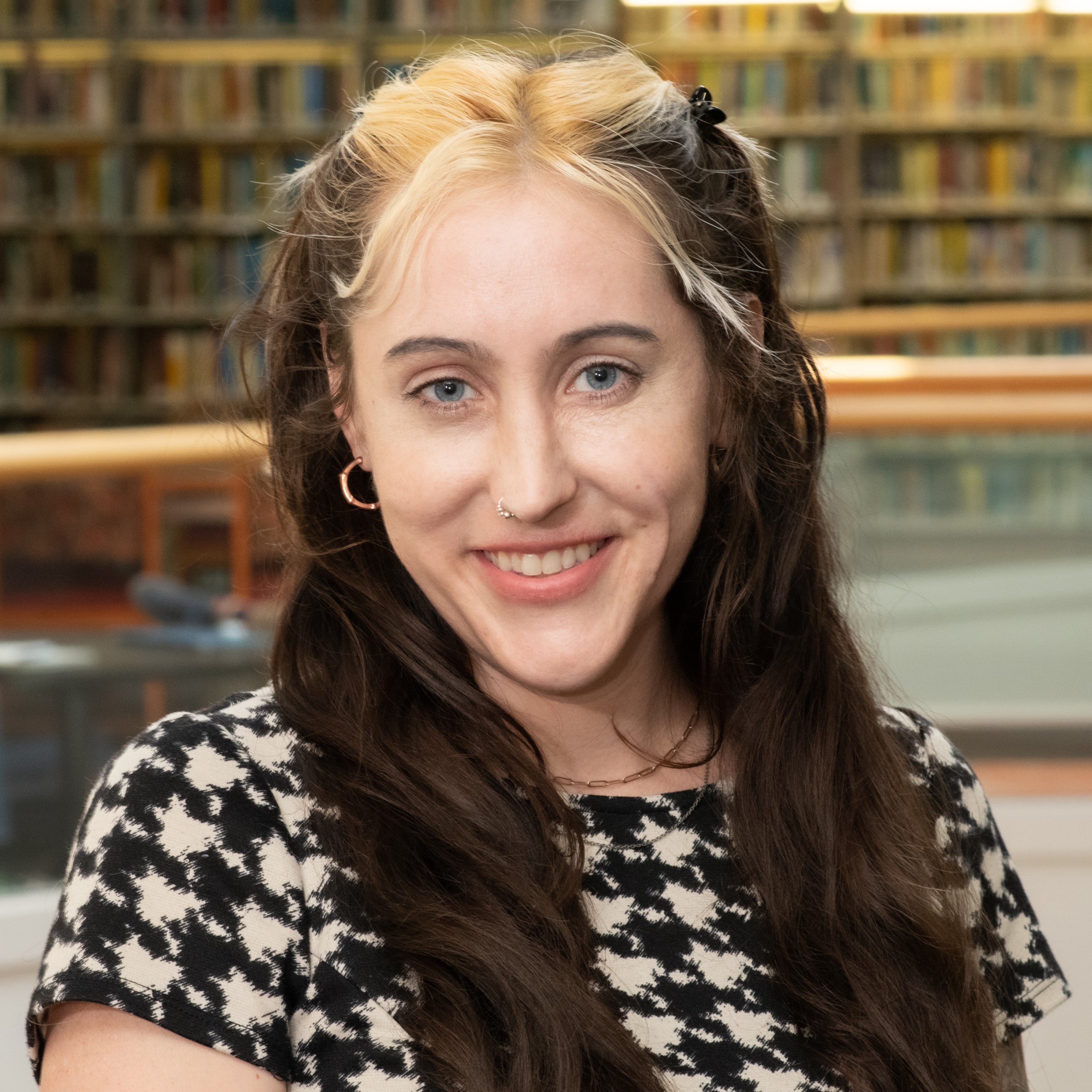 Headshot of Rachel Weidner with stacks behind her in Hagerty Library.